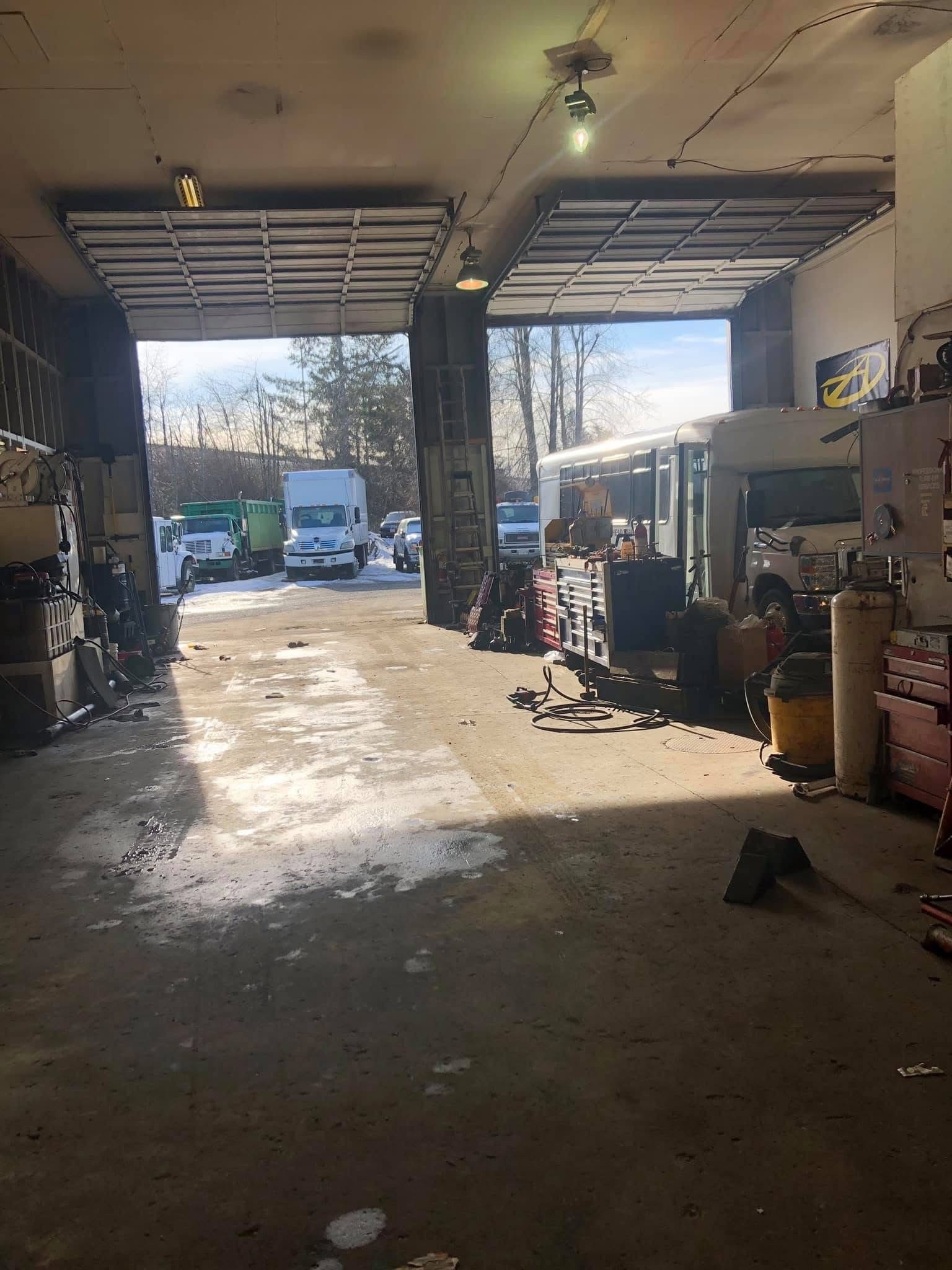 Shop bay open in winter with trucks outside
